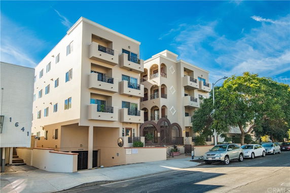 Front view of a multi-story apartment building with balconies.