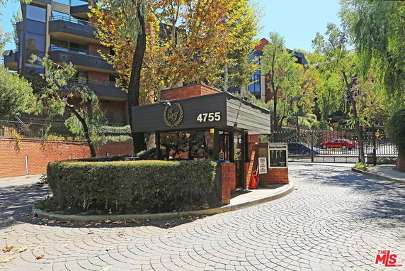 Front view of a multi-story building with a gated entrance.