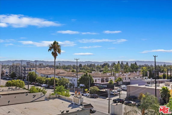 Wide angle view of urban area with buildings and trees in the distance.