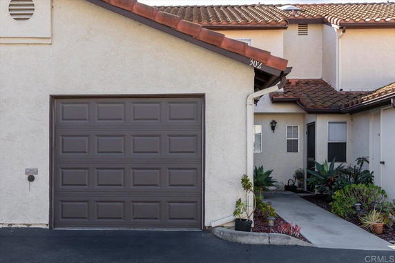 Front view of a house with an attached garage and tiled roof.