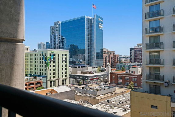 Cityscape view featuring multiple buildings, including a tall glass skyscraper and other commercial structures.