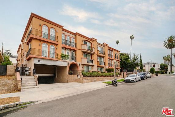 Front view of a multi-story apartment building with balconies.