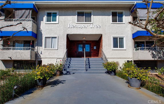 Front view of a multi-story building with stairs leading to the entrance.