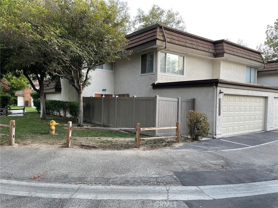 Front view of a two-story house with a double garage and fenced yard.
