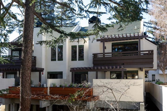 Front view of a multi-story building with balconies and large windows.