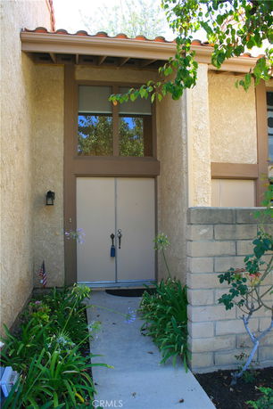 Front view of a house entrance with a double door and large window above.