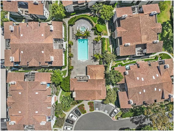 Aerial view of a residential complex with multiple buildings surrounding a central swimming pool.