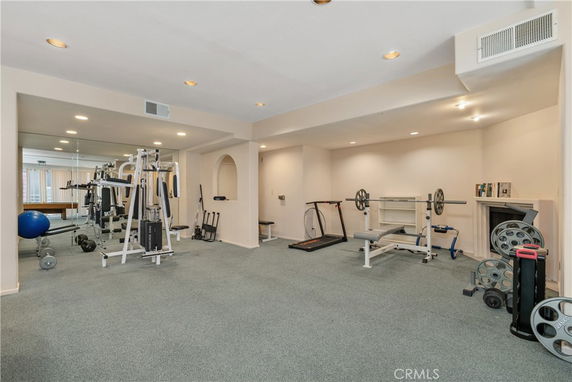 Indoor gym area equipped with exercise machines and weights.