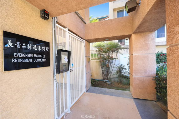 Entrance view of a retirement community building with a gated security access.