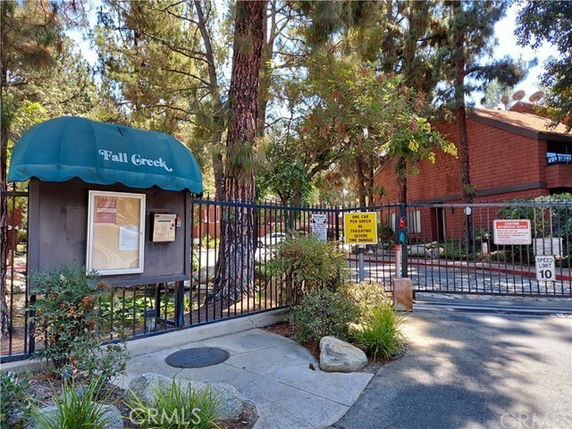 Front view of a gated community entrance with a canopy labeled 'Fall Creek'.