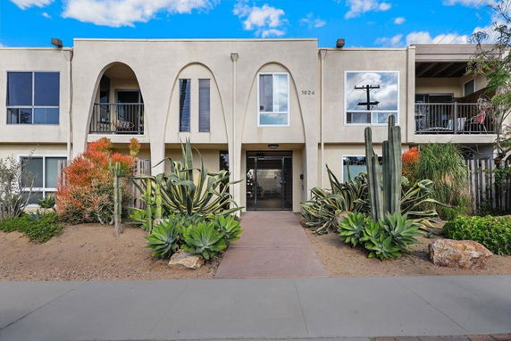 Front view of a two-story building with arched designs and balconies.