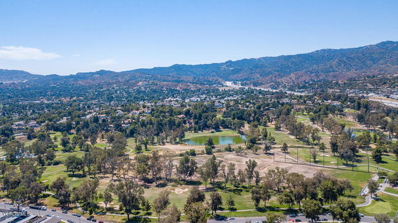 Wide angle view of a landscape with hills and a golf course.