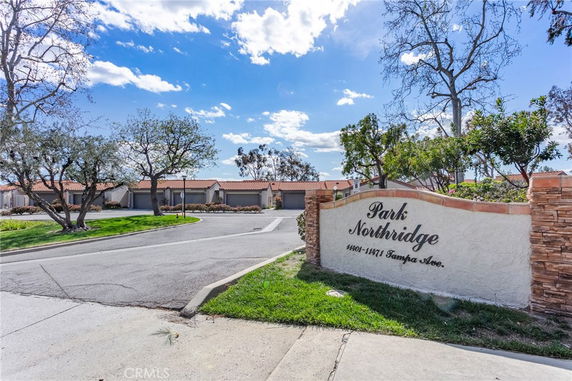 Front view of a residential complex with tiled roofs and a prominent entrance sign.