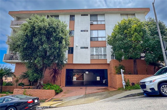 Front view of a multi-story building with a gated entrance.