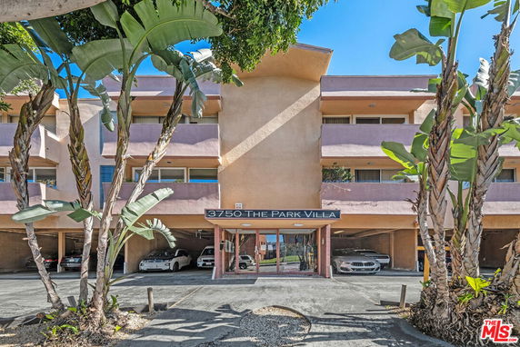 Front view of a multi-story residential building with covered parking and balconies.