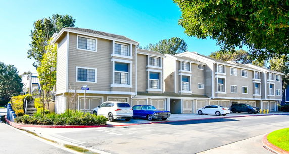 Front view of a three-story residential building with attached garages.