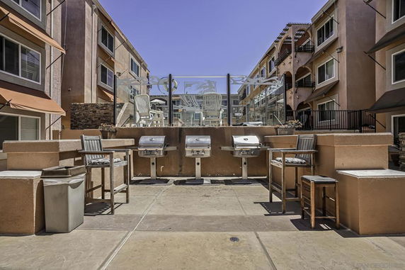 Outdoor grilling and seating area between apartment buildings.
