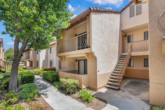 Front view of a two-story apartment building with staircases and balconies.
