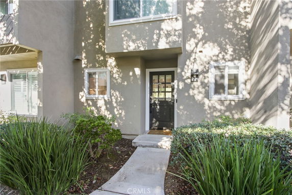 Front view of a house entrance with a black door and small windows.