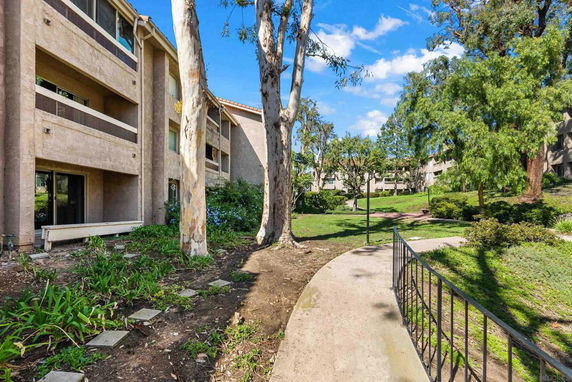 View of residential buildings surrounded by trees and gardens.