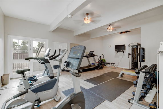 Home gym area with exercise equipment including treadmills and weights.