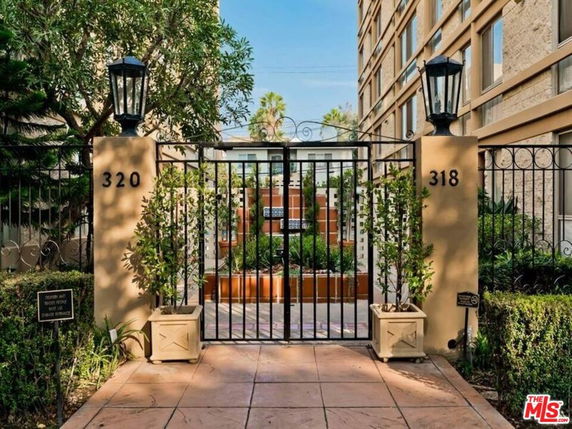Front view of an apartment building entrance with gated access.