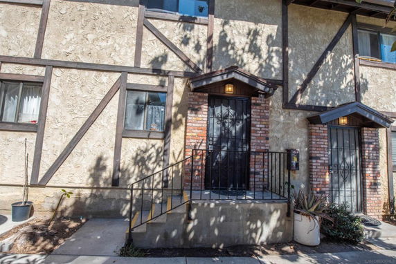 Front view of a multi-story building with brickwork and stucco finish.