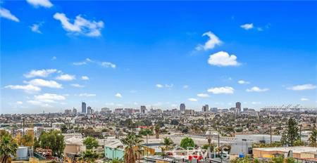 Panoramic view of a city skyline under a blue sky with clouds.