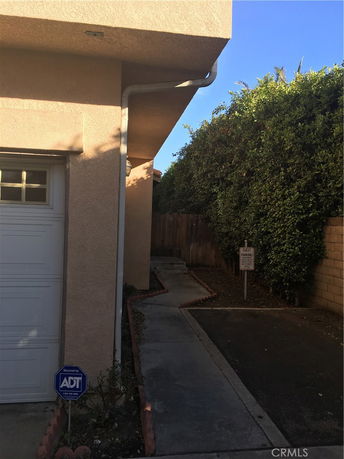 Side view of a house with pathway leading to the entrance.