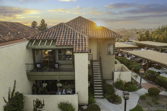 Front view of a two-story house with a tiled roof and exterior staircase.