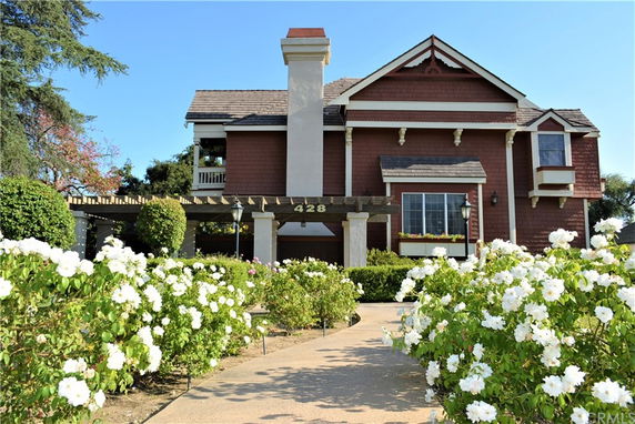 Front view of a two-story house with decorative shingles and a chimney.