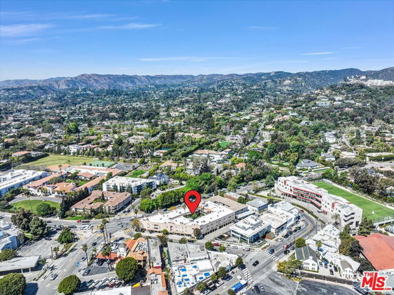 Panoramic aerial view of urban and suburban area with buildings and greenery.