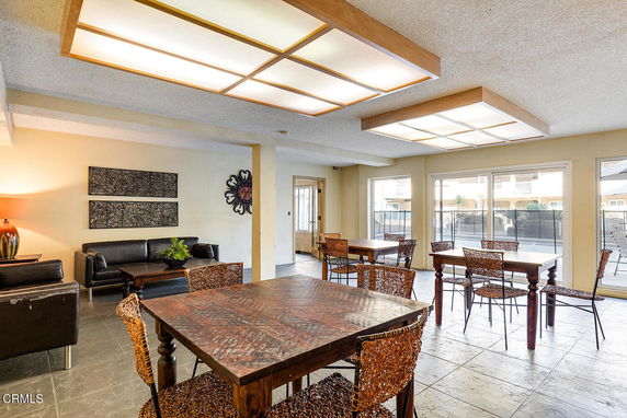 Interior view of a clubhouse area with tables, chairs, and a seating area.