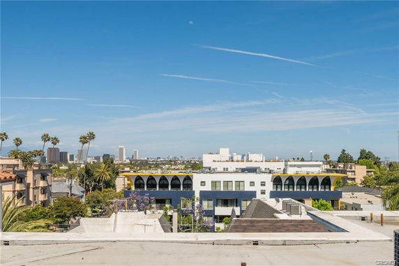 Panoramic view of cityscape with palm trees and buildings.