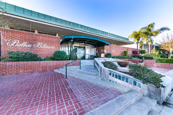 Front view of a brick building with a green canopy entrance.