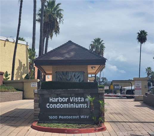 Front view of a condominium entrance with signage and gated entry.