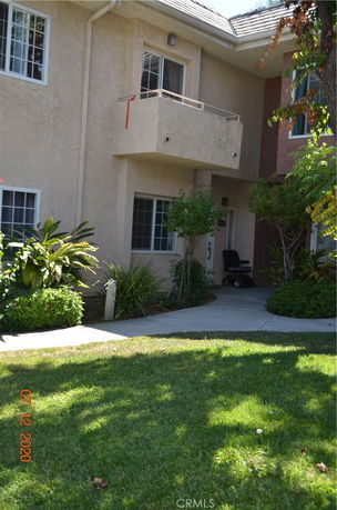 Front view of a two-story building with a balcony and entrance doorway.