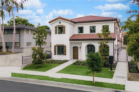 Front view of a two-story house with a tiled roof and multiple windows.