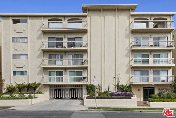 Front view of a multi-story apartment building with balconies.