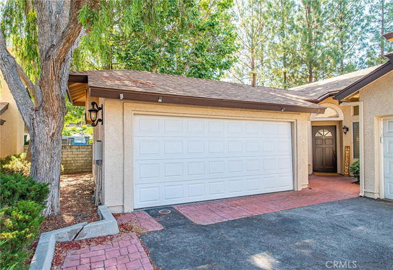 Front view of a house with a double garage and pathway leading to the entrance.