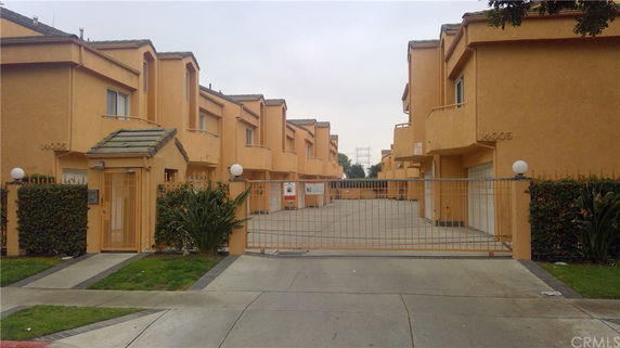 Front view of a multi-story residential building with gated entrance.