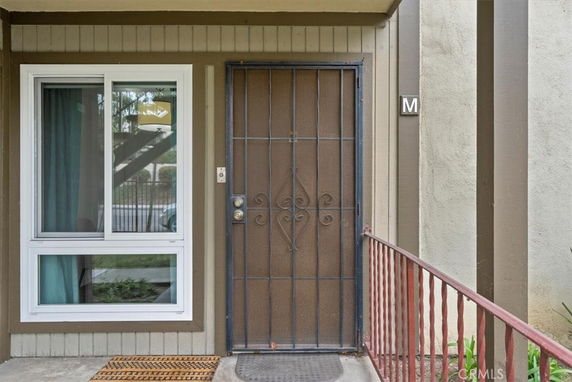 Front view of a building entrance with a security door and a window beside it.