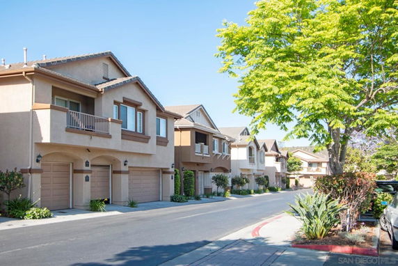 Front view of a row of two-story townhouses with attached garages.