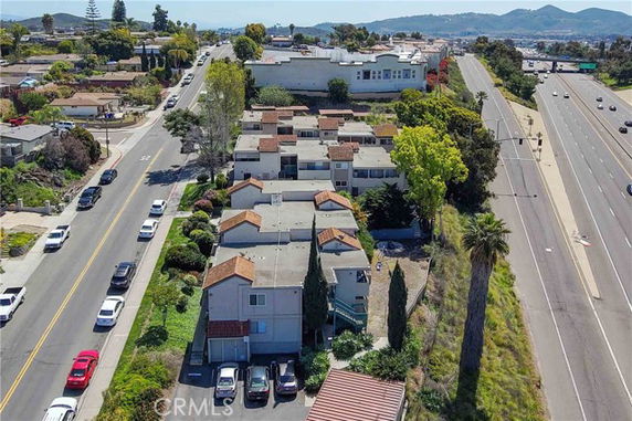 Aerial view of residential buildings alongside a street and highway.