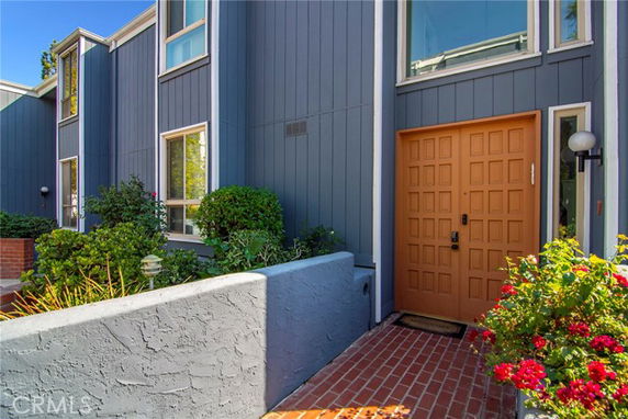 Front view of a modern house with blue paneling and a wooden door.