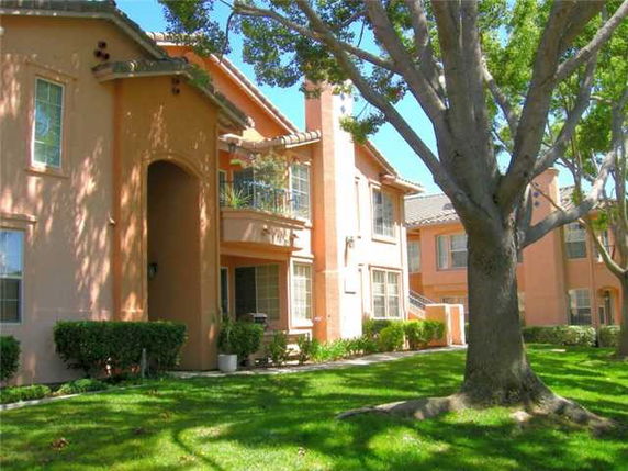 Front view of a two-story residential building with stucco exterior and balconies.