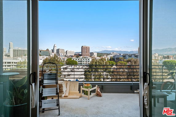 Panoramic cityscape view from a building balcony.