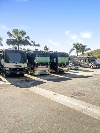 Outdoor parking area with multiple parked RVs under a clear sky.