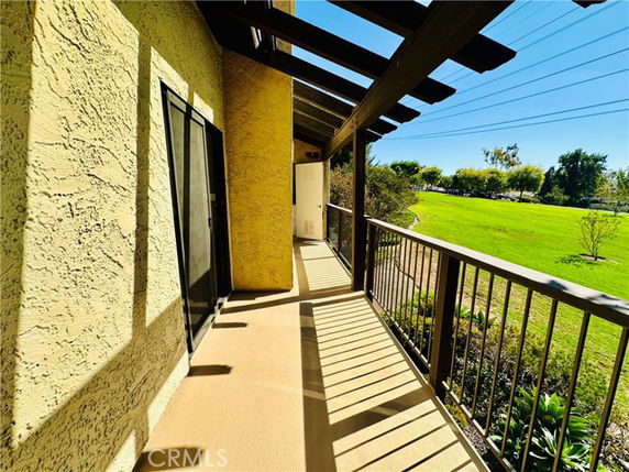 Balcony view with railing overlooking a grassy area.