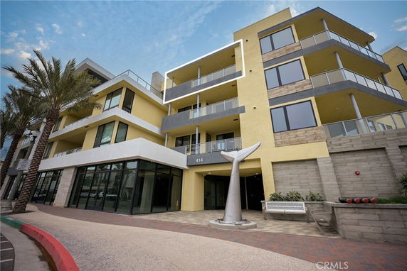 Front view of a multi-story modern building with balconies and large windows.